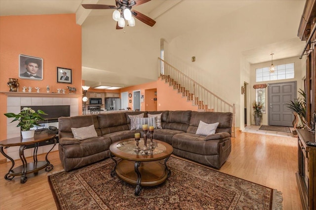 6305 N Marty Ave, Fresno, CA 93711 - living room with light wood-type flooring, high vaulted ceiling, a ceiling fan, and stairway