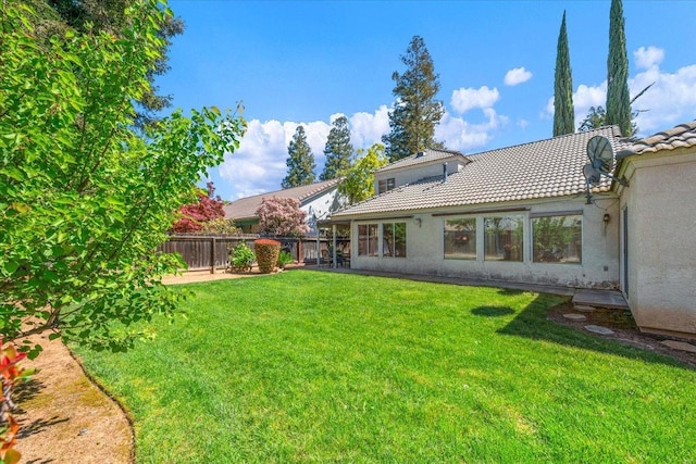 6305 N Marty Ave, Fresno, CA 93711 - rear view of property with a yard, stucco siding, fence, and a tiled roof
