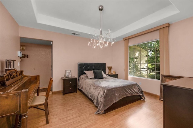 6305 N Marty Ave, Fresno, CA 93711 - bedroom with visible vents, baseboards, a raised ceiling, a chandelier, and light wood-style floors