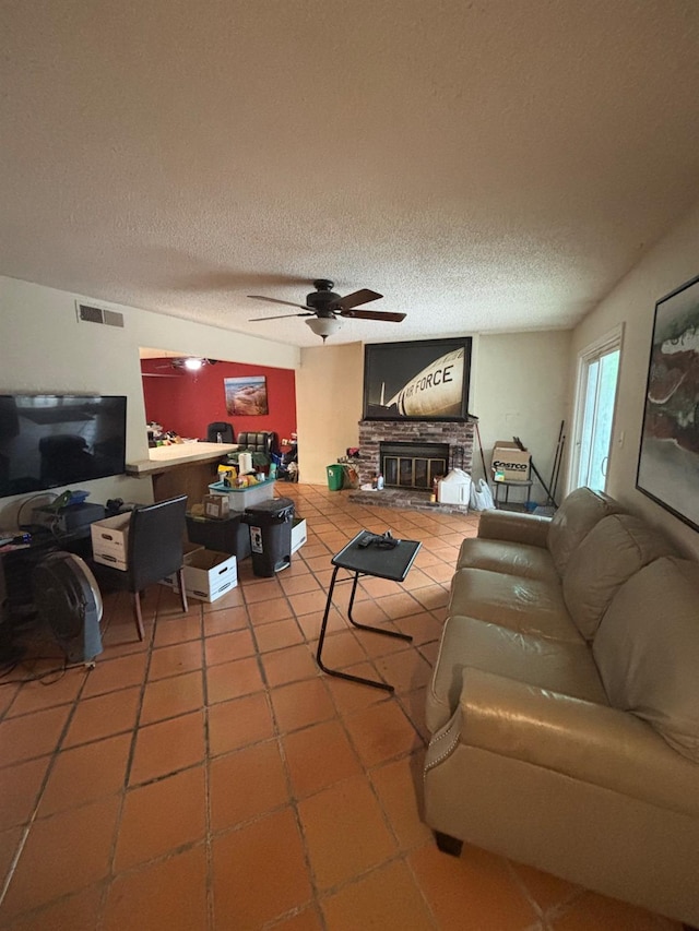 1225 Pontiac Ave, Clovis, CA 93612 - living room featuring tile patterned flooring, a ceiling fan, a glass covered fireplace, and a textured ceiling