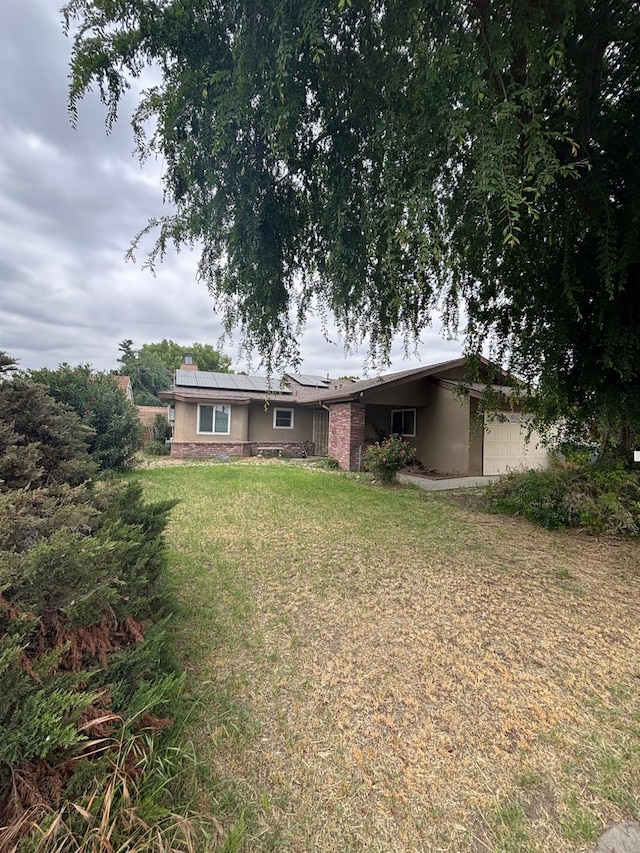 1225 Pontiac Ave, Clovis, CA 93612 - back of property featuring roof mounted solar panels, a lawn, and a garage