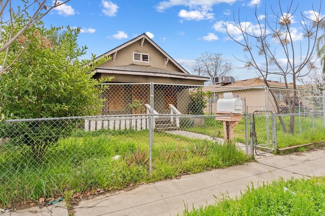 bungalow-style home featuring stucco siding, fence, and a gate