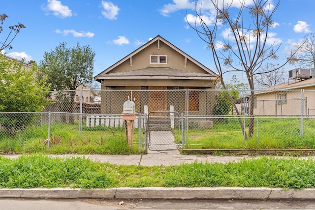 bungalow-style home featuring fence, stucco siding, and a gate