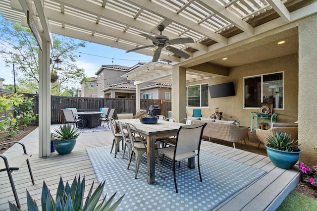 deck with an outdoor hangout area, outdoor dining area, a pergola, ceiling fan, and fence