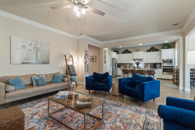 living room featuring light tile patterned floors, crown molding, a ceiling fan, visible vents, and baseboards