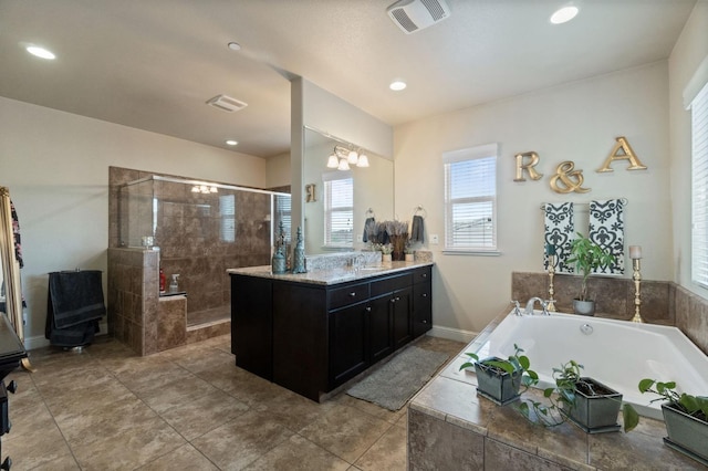 bathroom with visible vents, plenty of natural light, a garden tub, and tiled shower