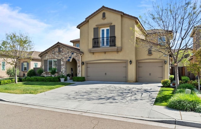 mediterranean / spanish home featuring a balcony, stucco siding, stone siding, concrete driveway, and an attached garage
