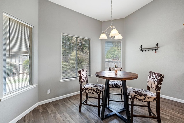 4650 W Roberts Ave, Fresno, CA 93722 - dining area with dark wood-style floors, a chandelier, and baseboards