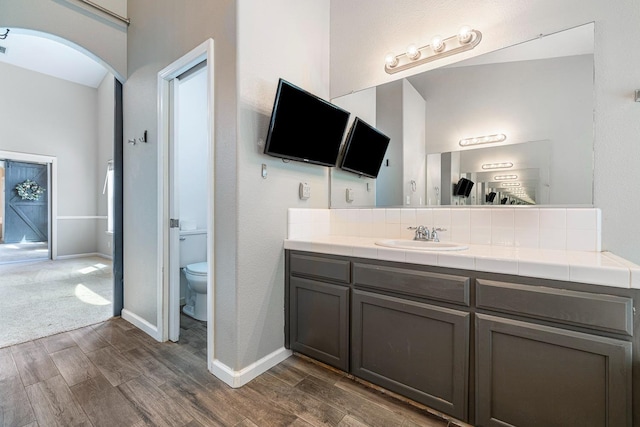 4650 W Roberts Ave, Fresno, CA 93722 - full bath featuring wood finished floors, vanity, toilet, and baseboards