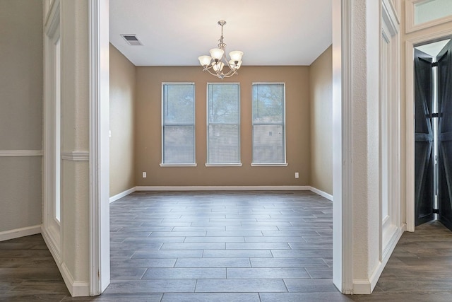 4650 W Roberts Ave, Fresno, CA 93722 - unfurnished dining area featuring dark wood-style flooring, a chandelier, and baseboards