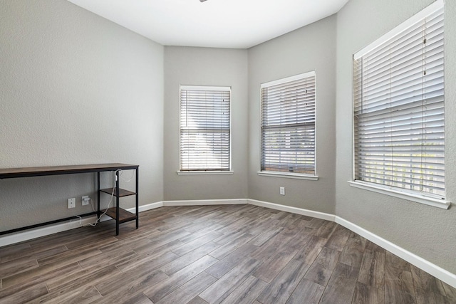 4650 W Roberts Ave, Fresno, CA 93722 - spare room featuring dark wood-style flooring, a textured wall, baseboards, and a baseboard heating unit