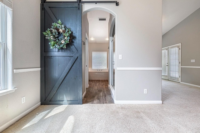 4650 W Roberts Ave, Fresno, CA 93722 - carpeted entryway featuring a barn door, arched walkways, and baseboards