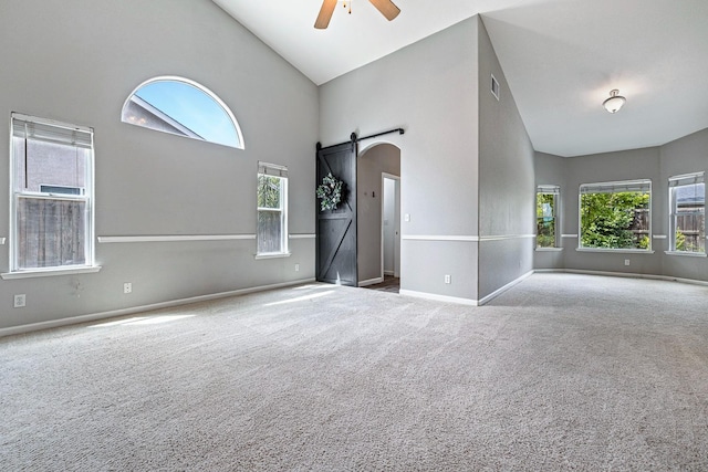 4650 W Roberts Ave, Fresno, CA 93722 - carpeted spare room with a barn door, a ceiling fan, plenty of natural light, high vaulted ceiling, and baseboards