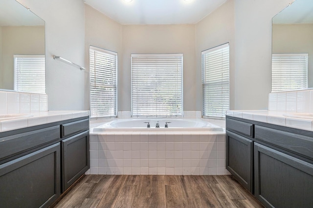 4650 W Roberts Ave, Fresno, CA 93722 - bathroom with wood finished floors, two vanities, plenty of natural light, and a garden tub