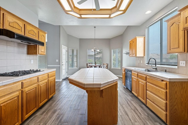 4650 W Roberts Ave, Fresno, CA 93722 - kitchen featuring tile countertops, a sink, wood finished floors, a kitchen island, and recessed lighting