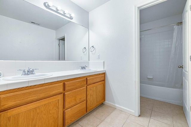 4650 W Roberts Ave, Fresno, CA 93722 - full bathroom featuring double vanity, tile patterned flooring, shower / bath combo with shower curtain, and baseboards