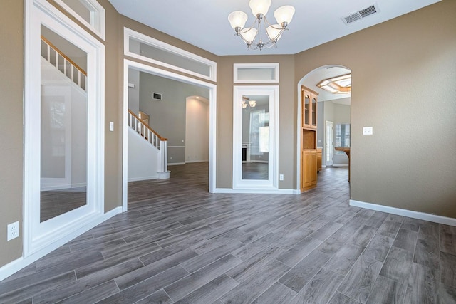 4650 W Roberts Ave, Fresno, CA 93722 - entryway featuring arched walkways, a chandelier, dark wood-style floors, and baseboards