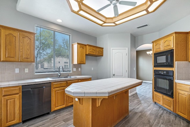 4650 W Roberts Ave, Fresno, CA 93722 - kitchen featuring black appliances, a sink, ceiling fan, wood finished floors, and decorative backsplash
