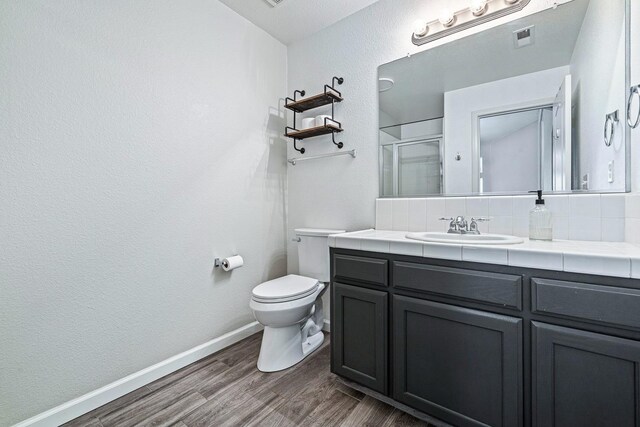 4650 W Roberts Ave, Fresno, CA 93722 - bathroom featuring vanity, wood finished floors, an enclosed shower, toilet, and baseboards