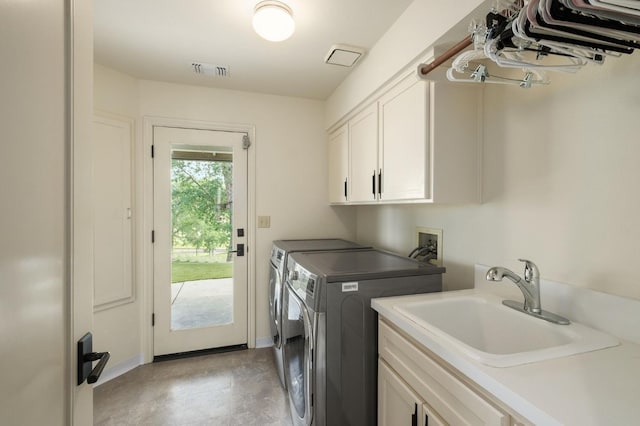 washroom featuring cabinet space, visible vents, a sink, and washing machine and clothes dryer