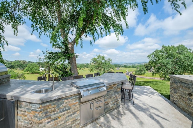 view of patio / terrace with exterior kitchen, a sink, outdoor wet bar, and area for grilling