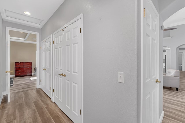 corridor with recessed lighting, arched walkways, attic access, and wood finished floors