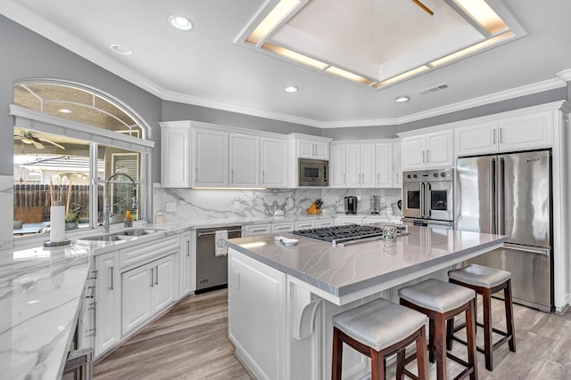 kitchen featuring appliances with stainless steel finishes, a sink, and white cabinetry