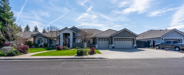 view of front facade featuring a tiled roof, stucco siding, a front yard, an attached garage, and concrete driveway