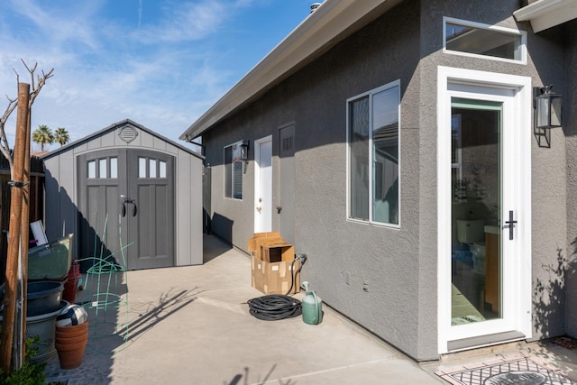 view of patio featuring an outdoor structure and a storage unit