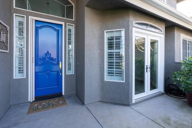 property entrance with french doors and stucco siding