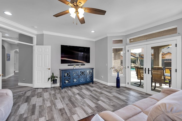 living room featuring baseboards, recessed lighting, ceiling fan, arched walkways, and wood finished floors