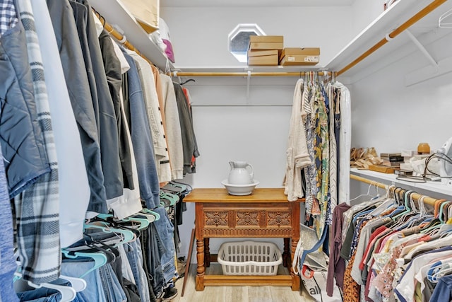 walk in closet with wood finished floors
