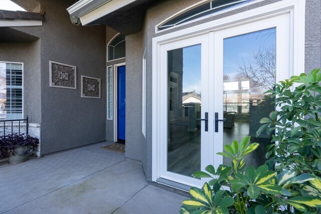 view of exterior entry with french doors and stucco siding