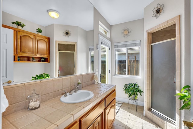 bathroom with baseboards, a shower stall, vanity, decorative backsplash, and tile patterned flooring