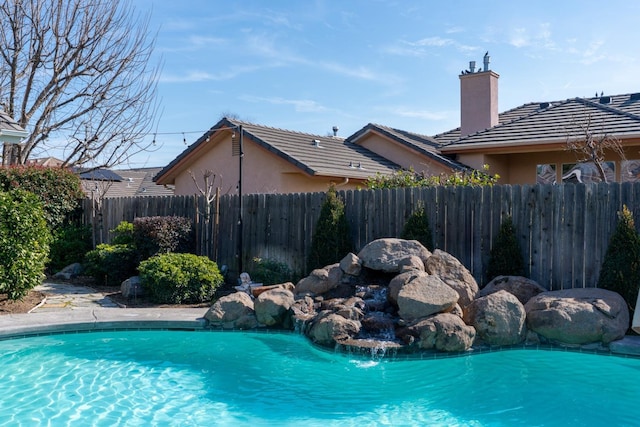 view of pool with a fenced in pool and fence