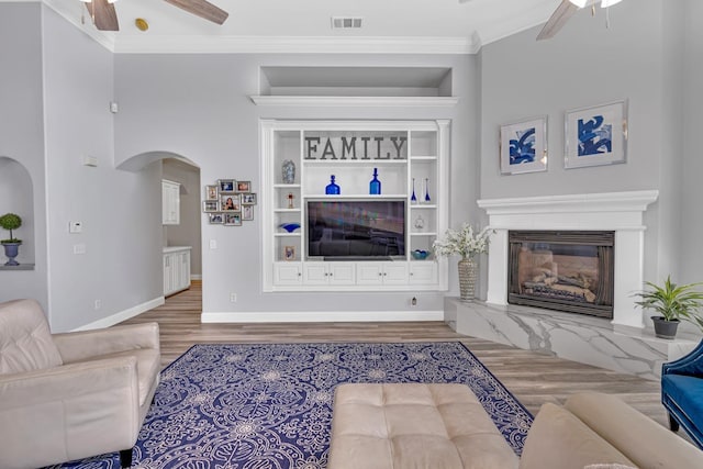 living room with arched walkways, wood finished floors, a ceiling fan, and visible vents