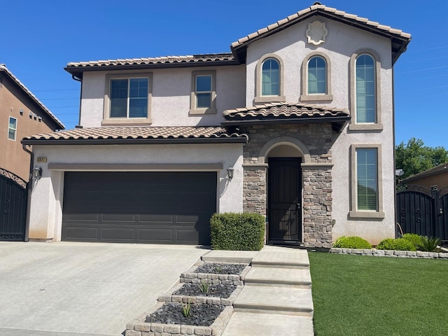 mediterranean / spanish-style home with a garage, driveway, a tile roof, and a gate