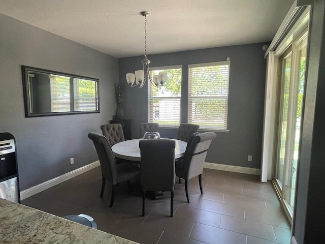 dining area featuring a wealth of natural light, an inviting chandelier, and baseboards