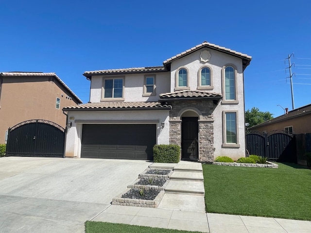 mediterranean / spanish home with a tiled roof, a garage, stucco siding, a gate, and driveway
