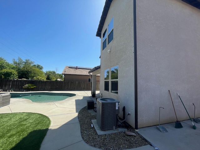 view of pool with a fenced in pool, a patio, central AC unit, and a fenced backyard