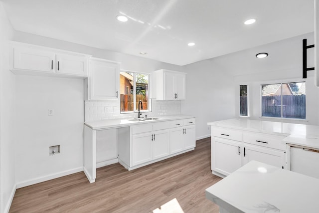 5873 W Wathen, Fresno, CA 93722 - kitchen featuring a sink, light wood-type flooring, decorative backsplash, white cabinetry, and recessed lighting