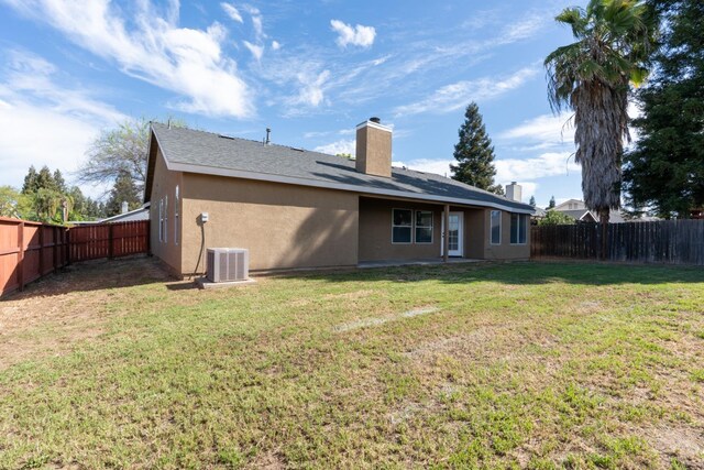 5873 W Wathen, Fresno, CA 93722 - back of house featuring a chimney, stucco siding, and central AC
