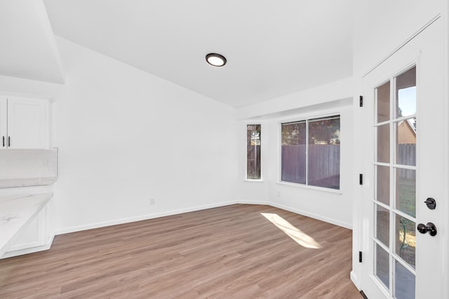 5873 W Wathen, Fresno, CA 93722 - empty room with light wood-style floors, baseboards, and lofted ceiling