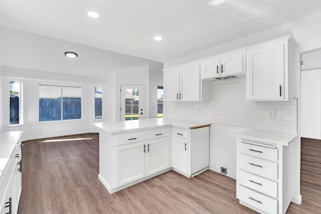 5873 W Wathen, Fresno, CA 93722 - kitchen featuring light wood-type flooring, tasteful backsplash, white cabinets, recessed lighting, and a peninsula