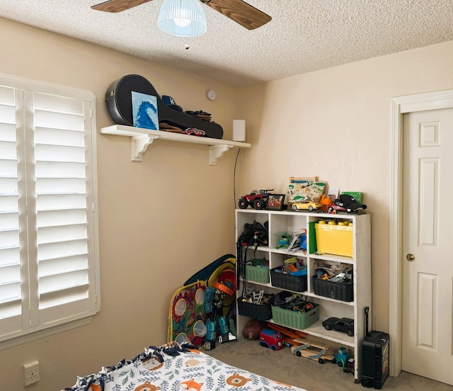 carpeted bedroom with a textured ceiling and a ceiling fan