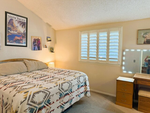 carpeted bedroom featuring a textured ceiling, vaulted ceiling, and baseboards