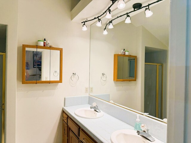 full bathroom with a shower stall and double vanity