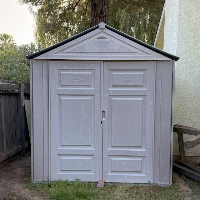 view of shed featuring fence