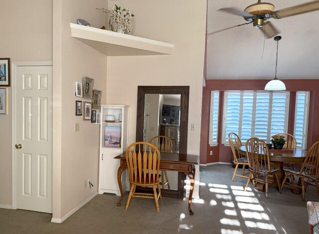 dining area with a ceiling fan, carpet, baseboards, and vaulted ceiling
