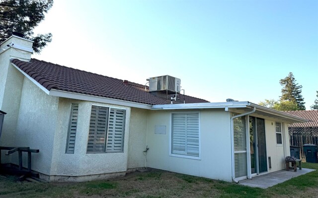 back of property featuring central AC and stucco siding